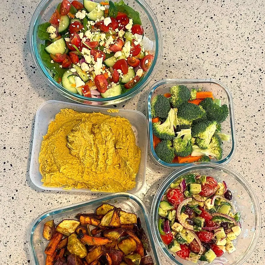 Fresh salads, hummus and roast vegetables prepped in glass bowls